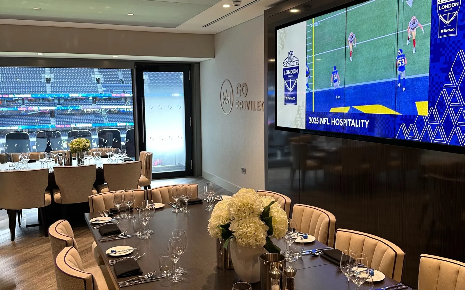 Elegant private dining space within the Super Suite overlooking Tottenham Hotspur Stadium through floor-to-ceiling windows.