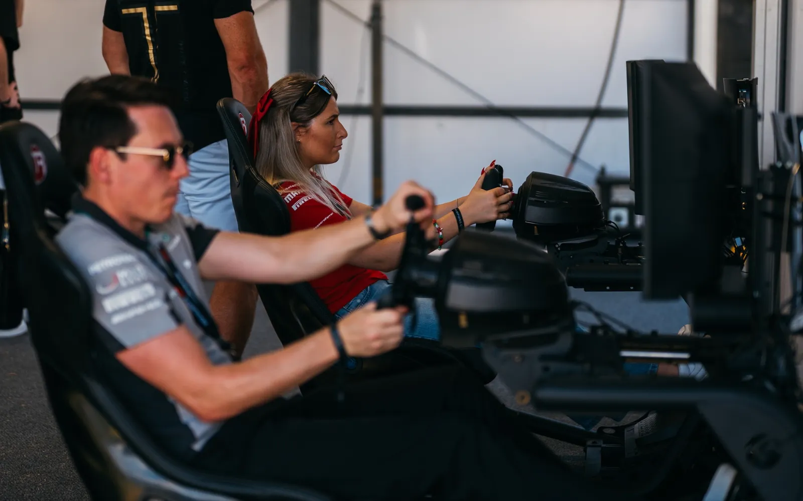 Guests using Formula 1 racing simulators inside F1 Paddock Club Hospitality suite