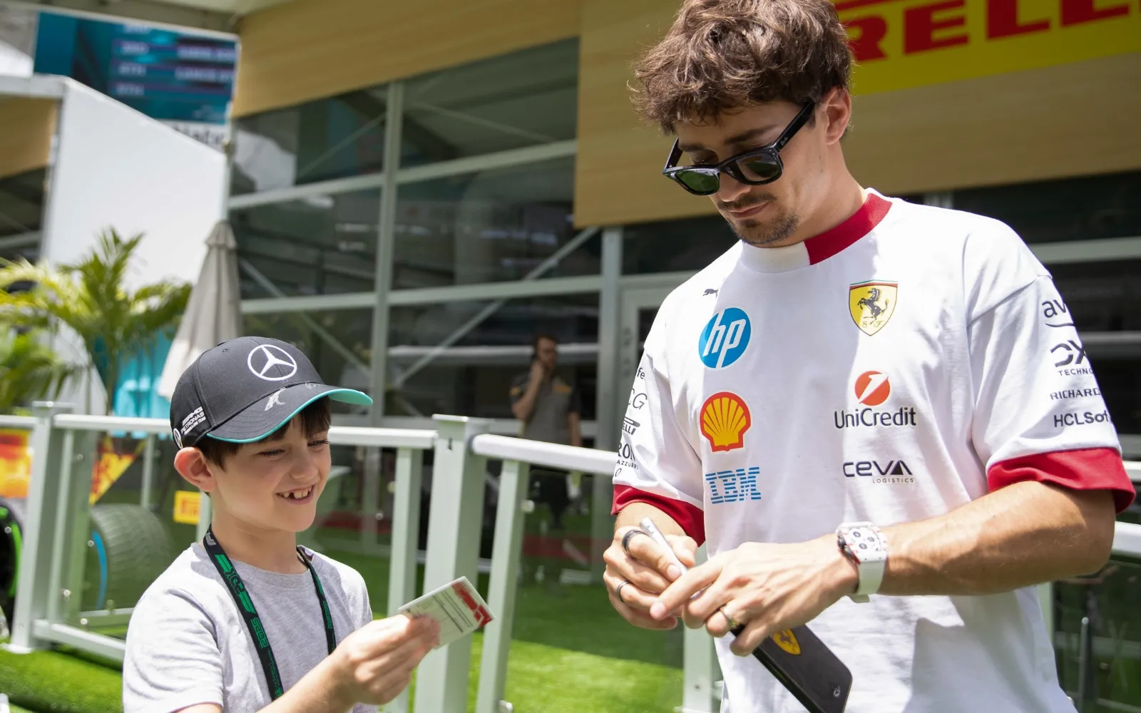 Formula 1 driver signing autograph for fan in Paddock Club hospitality