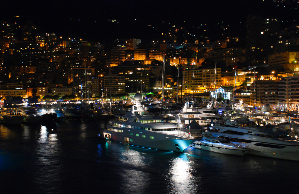 Evening skyline of Monte Carlo with lights reflecting on the marina